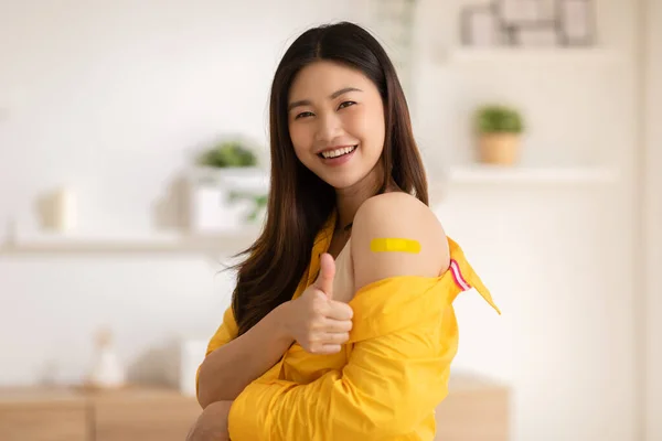 幸せなアジアの女性は包帯で陽気な親指を抗ウイルスワクチンを受けました 若い女性はCovid 19ワクチン接種を取得した後 将来の安全性の生活に楽しさと自信を持って ワクチン接種コンセプト — ストック写真