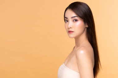 Güzel Asyalı kadın gülümsemesi temiz ve taze tenli mutlu ve neşeli, olumlu duygusal, bej arka planda soyutlanmış, güzellik ve kozmetik anlayışı