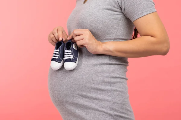 Nahaufnahme Schwangere Frau Hält Baby Turnschuhe Für Neugeborene Isoliert Auf — Stockfoto