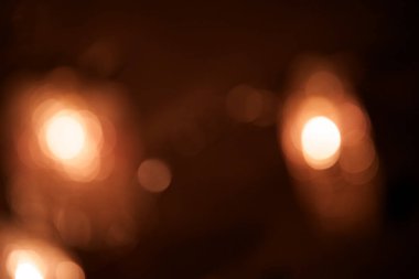 Parlak bulanık ışıklar, kırmızı renkli neşeli çelenkler. Ateşli kırmızı bokeh, pırıl pırıl parlayan arka plan.