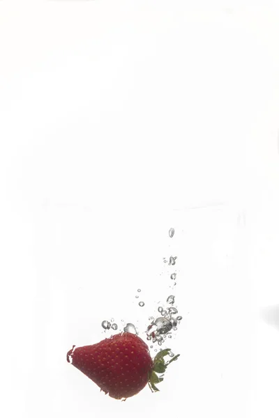 Strawberry dropped into water — Stock Photo, Image