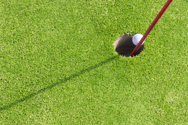 Mini golf ball going in the  hole — Stock Photo, Image