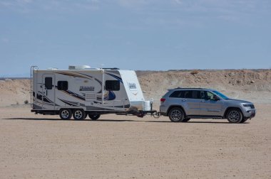 Mojave Çölü, Kaliforniya, ABD - 17 Eylül 2021: Çölde park halindeki Grand Cherokee Jeep 'in çektiği bir seyahat karavanı görüntüsü.