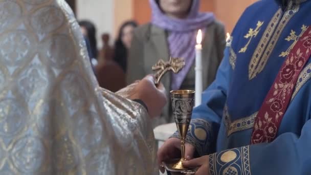 アルメニア教会で結婚式を挙げる 結婚式の際に教会のキリスト教の司祭はワインのカップを保持しています — ストック動画