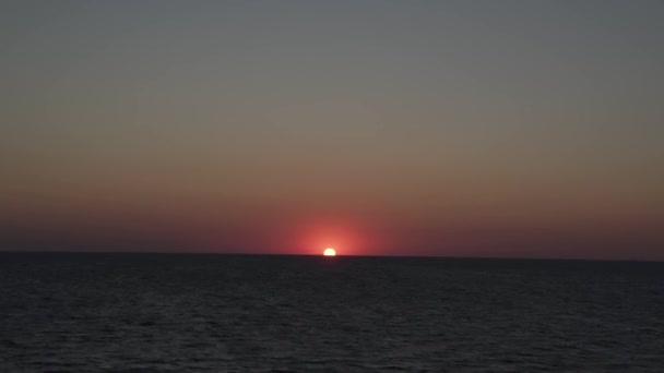 太阳从地平线上升起 掠过大海和大海 红色的天空 黄色的太阳和迷人的大海 日出时的夏日风景 浮云中的阳光是奇异的自然美 — 图库视频影像