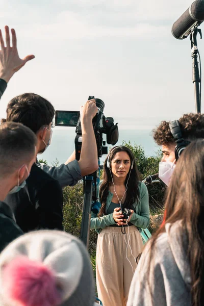 Behind the scenes of students filming a movie. Camera operator, sound technician, the actress in the middle and the director raising their hands