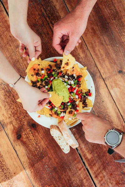 Foto Vertical Amigos Manos Compartiendo Nachos Con Guacamole Carne Encima — Foto de Stock