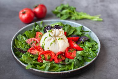 Geleneksel İtalyan burrata peynirli salata, domates, fesleğen ve roka.
