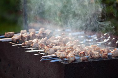 Portatif barbeküde pişen dumanlı ızgara et.