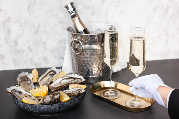 Hand of waiter with white glove is holding champagne