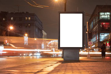 Dikey reklam panosu kenti. Gece şehrinde şehir formatı. Şehirdeki parlak reklam alanı Mockup 'ı. Yakınlarda bulanık arabalar sürüyorlar.