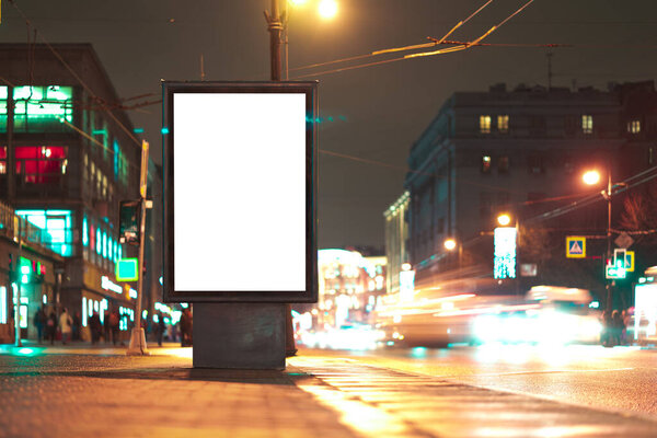 Vertical advertising billboard urban. city format in the night city. Luminous advertising field Mockup. Driving blurry cars nearby