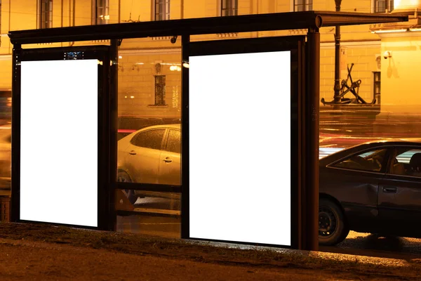 两个广告牌在一个车站附近的发光盒 在城市的夜晚 白色的广告领域闪烁着光芒 垂直场模拟 — 图库照片