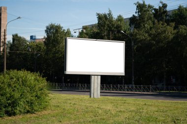 Şehirdeki ilan panosu. Reklam için beyaz reklam alanı. Yazın yeşilliğe karşı reklam panosu