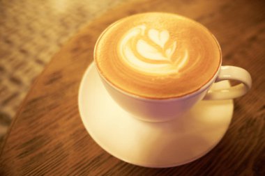 Ahşap masada bir fincan kahve sanatı.