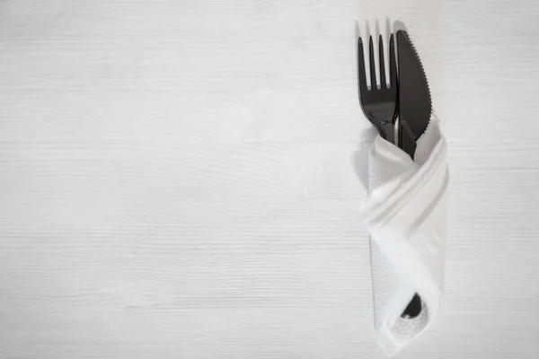 Μαχαιροπίρουνα Πιρούνι Και Μαχαίρι Πλαστικό Μαύρο Λευκό Φόντο Τυλιγμένο Χαρτοπετσέτα — Φωτογραφία Αρχείου