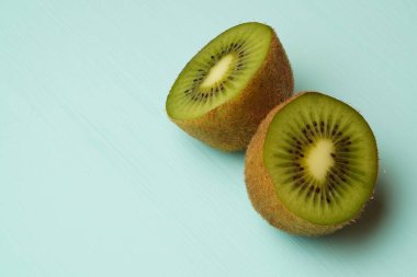 Yeşil arka planda iki yarım kivi.