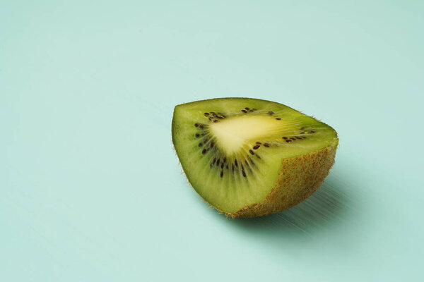 half kiwi on a green background. Sliced piece of fruit