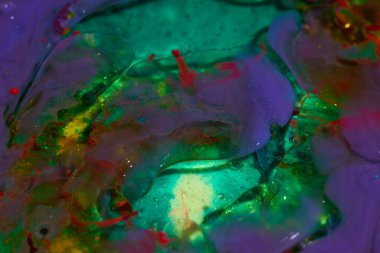 Su yüzeyindeki bir boya damlasının soyut arkaplanı. mavi mor yeşil renk