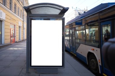 Otobüs durağında dikey reklam panosu reklamı. Reklam pankartlarına yerleştirilmek için beyaz kutu. Yolun yakınındaki şehirde yer alır..
