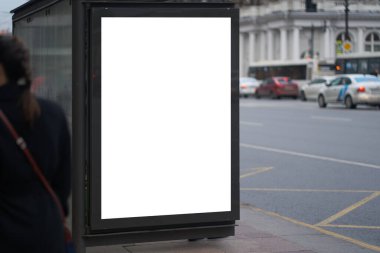 Otobüs durağında dikey reklam panosu reklamı. Reklam pankartlarına yerleştirilmek için beyaz kutu. Yolun yakınındaki şehirde yer alır..