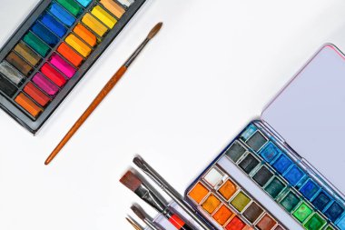 Beyaz kağıda, püsküllere, kalemlere, suluboya resimlere, pastel sanat malzemelerine yassılaştırılmış sanat materyalleri.