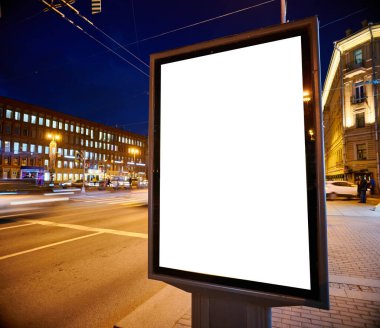 Sokaktaki ilan panosu geceleri parlıyor. Reklam tasarımı için tasarım. Beyaz bir alanı olan açık renkli sütun.
