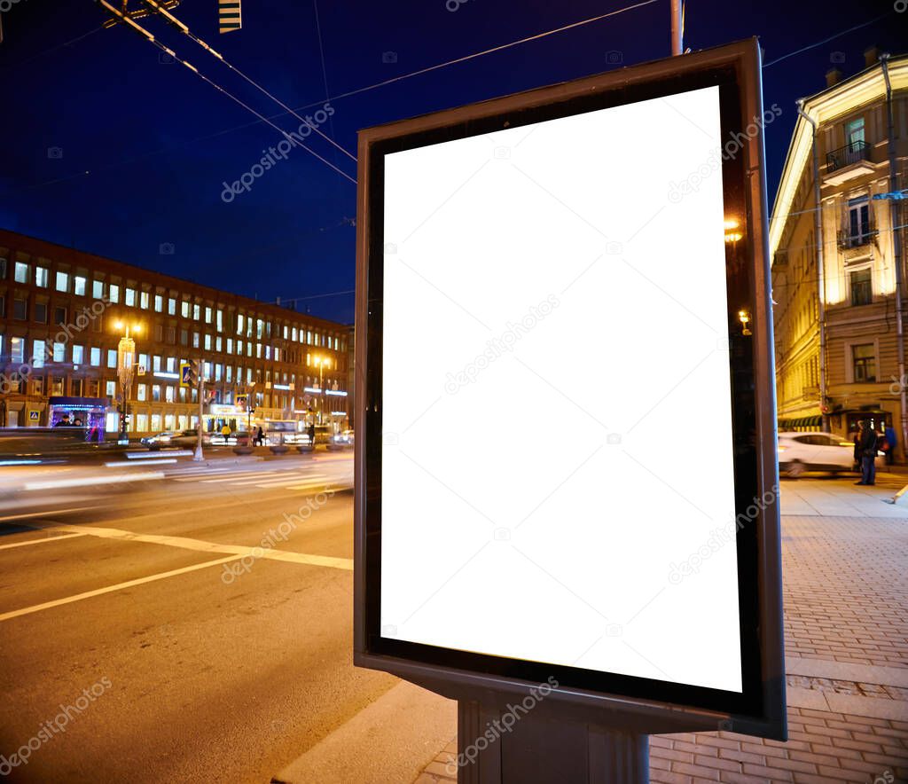 Billboard on the street glows at night. Layout for advertising design. Lightposter pylon with a white field.