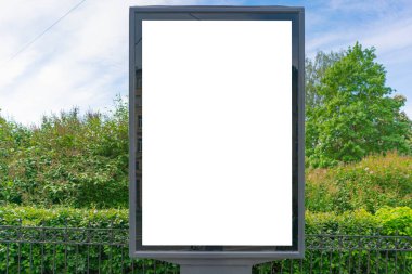 Ağaçların yeşili ve mavi gökyüzünün arka planına karşı dikey reklam panosu. Reklamcılık için bir yeri var.