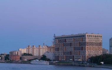 Nehirde çürümüş bir tatil teknesi olan şehrin manzarası. Turist teknesi büyüklüğünde.