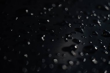 Hidrofobik yüzeylere toplar halinde soyut damlalar. karanlık yüzey bulanık