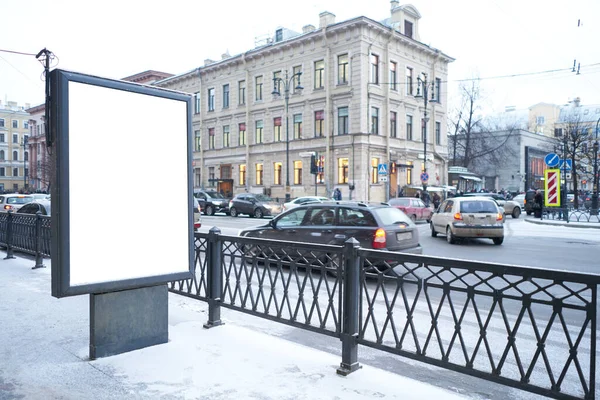 Vertical city billboard with white field MOCKUP. In the city center in the afternoon with snow in the winter outdoor advertising ad.