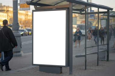 Otobüs durağındaki reklam panosundaki dikey ışık kutusu. Arka planda insanların olduğu MOCKUP reklamı için