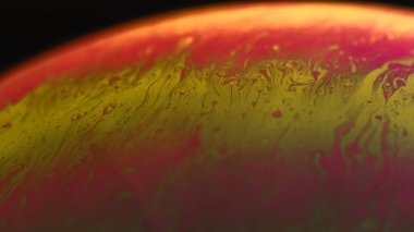 Sabun köpükleri soyut makro fotoğraf güzel psikedelik soyutlama kırmızı-sarı gölgeler siyah arka plan. küre yüzeyi