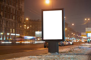 Şehirde geceleri reklam panolarının dikey ışık kutuları parlıyor, yol kenarındaki sokakta..