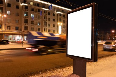 Geceleri şehirde kışın dikey reklam panosu formatı. Beyaz alan ile reklam tasarımı MOCKUP.