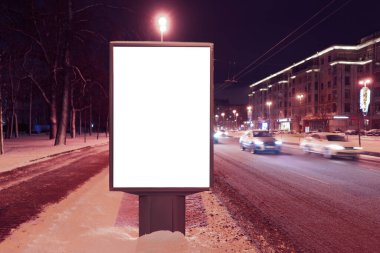 Geceleri şehirde kışın dikey reklam panosu formatı. Beyaz alan ile reklam tasarımı MOCKUP.