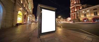 Geceleri şehrin arka planında bir poster afişi. Otobüs durağında maket yaparken..