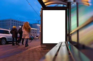 Billboard beyazı. Akşamları sokakta, arka planda, durak köşkünde insanlar...