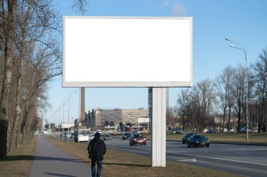 İlan panosu reklam kanvası. Yol kenarında duran insanlar için adam ve araba için yol. Güzel meteoroloji parkının arka planında reklam kanvası modeli