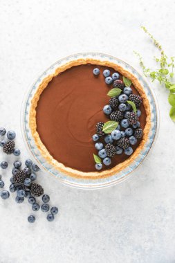 Taze yaban mersini ve nane ile süslenmiş koyu çikolatalı kremalı tart. 