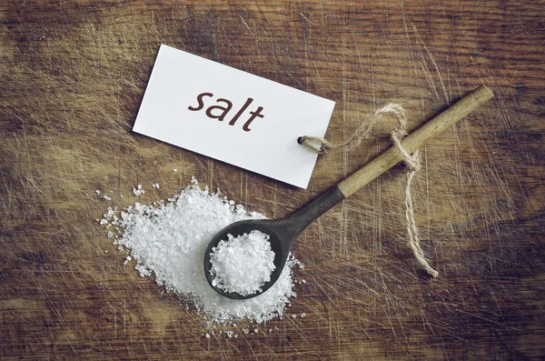 Морская соль в деревенской ложке — стоковое фото