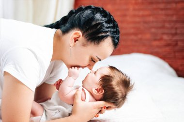 Avrupa görünümlü yeni doğmuş bir çocuk annesinin yanında yatıyor.
