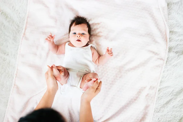 Mam doet gymnastiek voor een pasgeboren baby. Moeder en pasgeboren baby. De eerste maand van de moeder en kinderen leven thuis. Het beeld van een gelukkig moederschap en een gelukkig gezin — Stockfoto