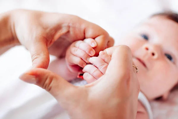 Manos diminutas de un bebé recién nacido en manos de una mujer en la forma de un primer plano del corazón. Mamá y su bebé. El concepto de una familia feliz. Una hermosa imagen conceptual de la maternidad —  Fotos de Stock
