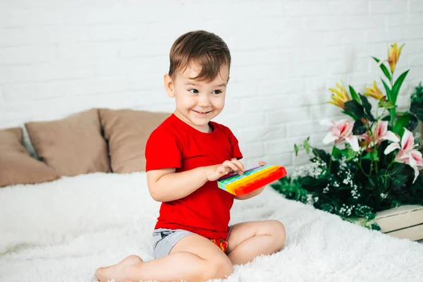 Liten Pojke Sitter Hemma Sängen Spelar Pop Nya Stress Leksak — Stockfoto