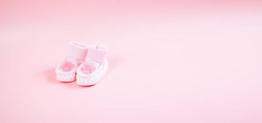 Pembe arka planda bir ayı resmi olan bebek pembe ayakkabılar..