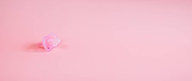 Pembe renkli ortodontik emzik, pembe arka planda izole edilmiş. Kullanım belirtileri gösteriyor. Sahte arkaplanda metin için boşluk.