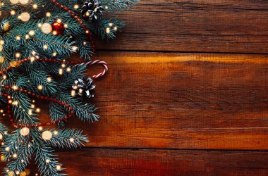 Noel ağacıyla süslenmiş dağınık ışıklardan yapılmış ahşap bir Noel arkaplanı. Metin için boşluk