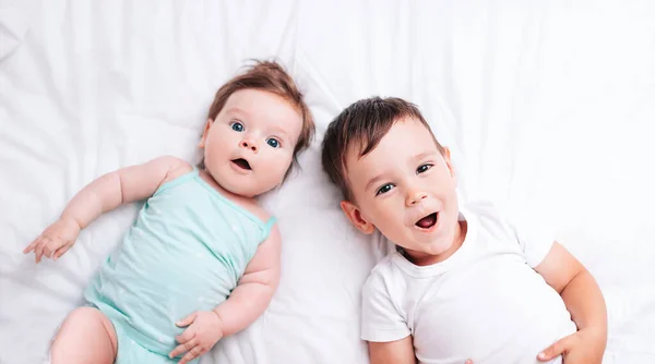 Happy Little Brother Hugs His Little Sister Lying White Blanket — Stock Photo, Image